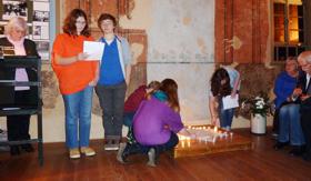 Schüler/innen entzünden in der Synagoge Kerzen