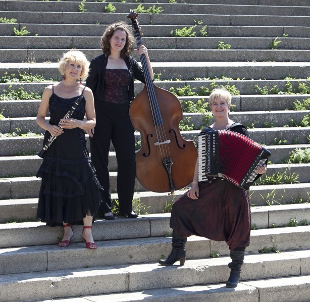 Gruppe von drei musizierenden Frauen auf einer Treppe