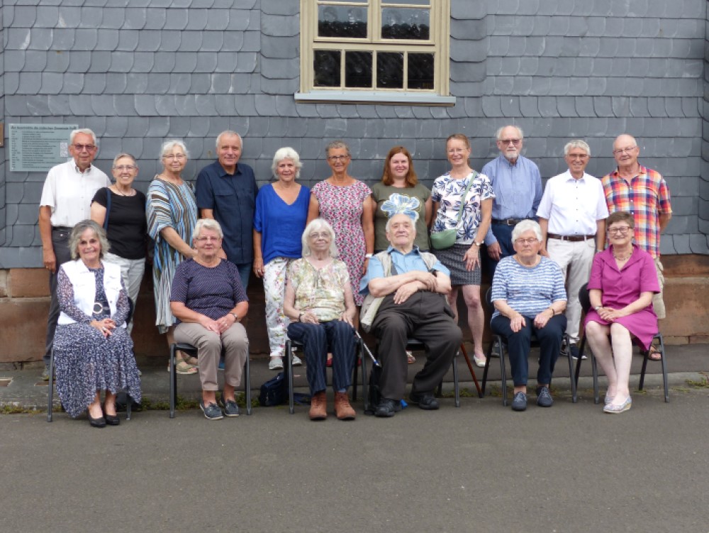 17 people in the group photo in front of the synagogue